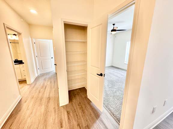 A room with a white door and a mirror on the wall.