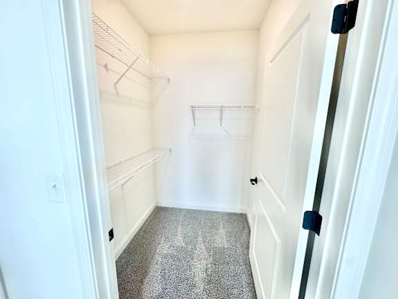 A small, empty room with a carpeted floor and white walls.