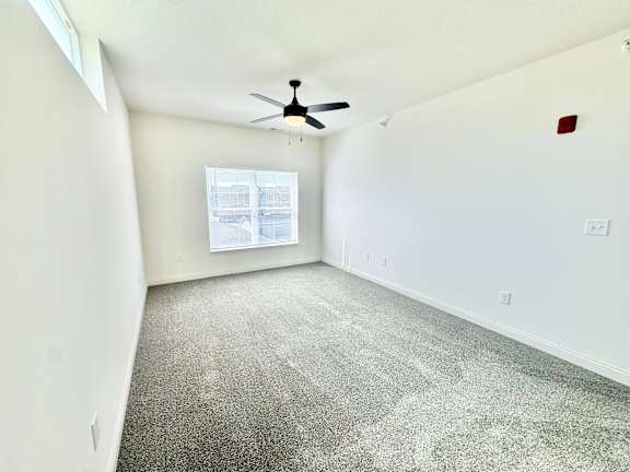 A room with a ceiling fan and a window.