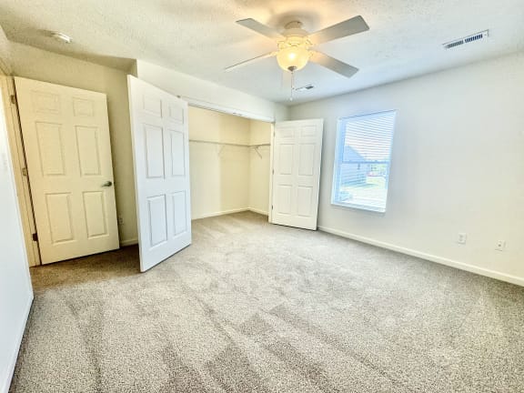 an empty living room with a ceiling fan and a closet at Hawthorne Properties in Lafayette, IN 47905