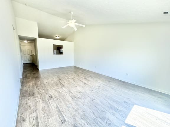 an empty living room with white walls and wood flooring at Hawthorne Properties in Lafayette, IN 47905