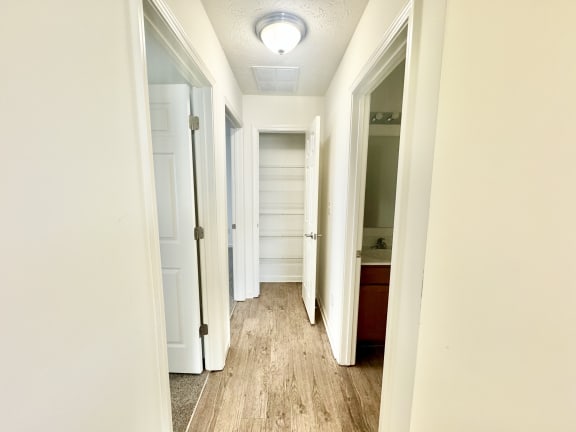 the hallway of a home with white walls and wood floors at Hawthorne Properties in Lafayette, IN 47905