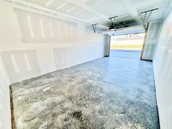 A spacious garage with a concrete floor and white walls.