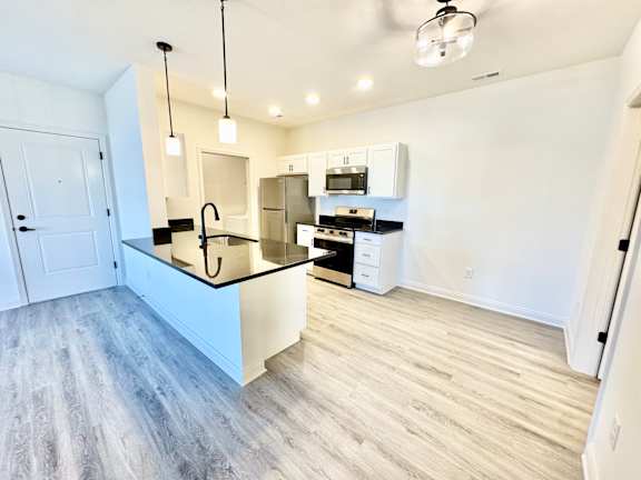 A kitchen with a white counter and a sink.