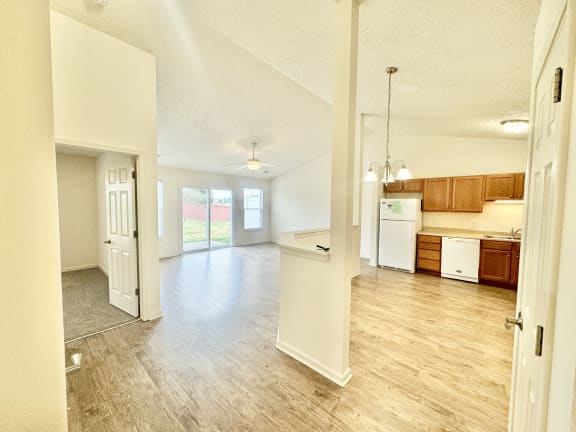 an empty living room and kitchen with a hard wood floor at Hawthorne Properties in Lafayette, IN 47905