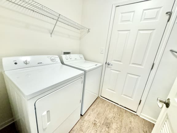 a laundry room with a washer and dryer and a white door at Hawthorne Properties in Lafayette, IN 47905
