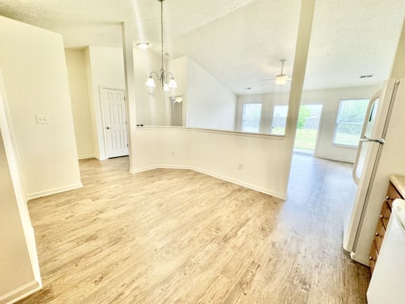 an empty kitchen and living room with a wood floor at Hawthorne Properties in Lafayette, IN 47905