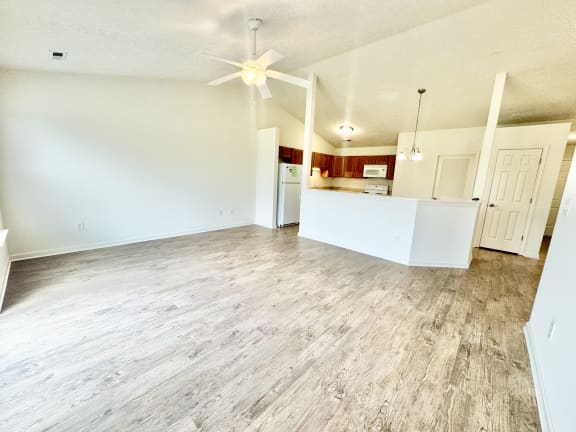 an empty living room with a ceiling fan and a kitchen at Hawthorne Properties in Lafayette, IN 47905