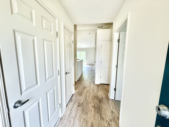 the hallway of a home with white doors and wood floors at Hawthorne Properties in Lafayette, IN 47905