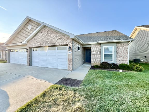 a house with a white garage door and a driveway at Hawthorne Properties in Lafayette, IN 47905