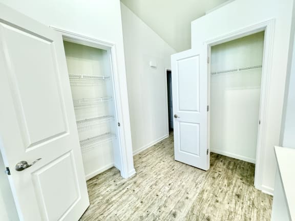 an empty closet with white doors and a wood floor at Hawthorne Properties in Lafayette, IN 47905