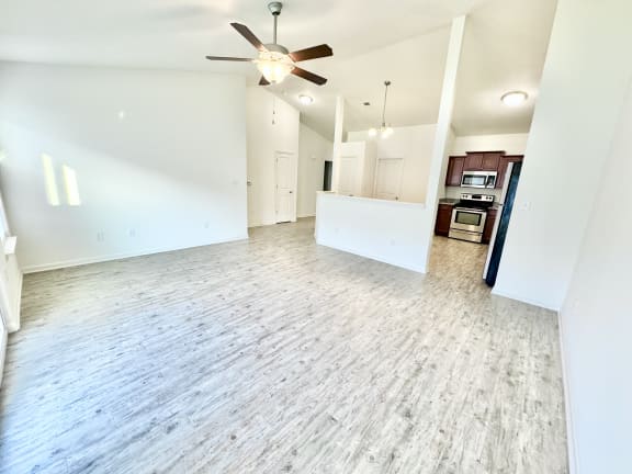 an empty living room with a ceiling fan and a kitchen at Hawthorne Properties in Lafayette, IN 47905