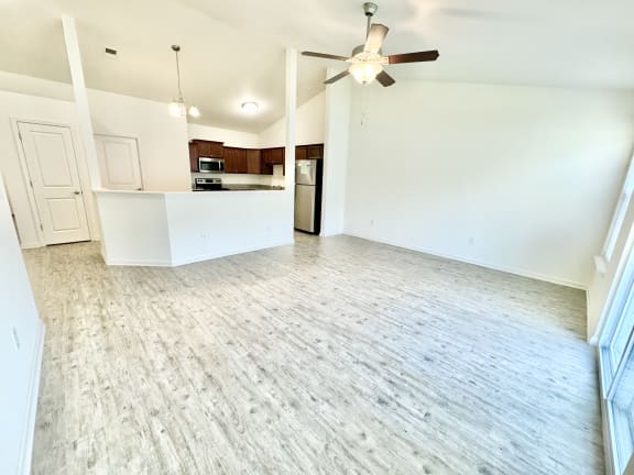 an empty living room and kitchen with a ceiling fan at Hawthorne Properties in Lafayette, IN 47905
