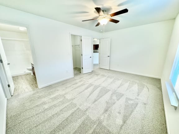 an empty living room with a ceiling fan and white walls at Hawthorne Properties in Lafayette, IN 47905