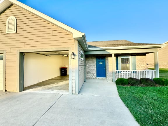 a sidewalk in front of a house with a blue door at Hawthorne Properties in Lafayette, IN 47905