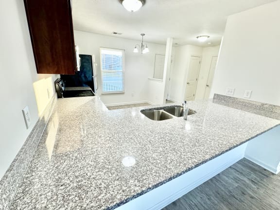 an open kitchen with granite counter tops and a sink at Hawthorne Properties in Lafayette, IN 47905