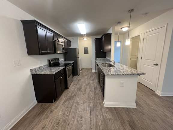 a kitchen with granite counter tops and black cabinets at Murdock Gardens Apartments, Lafayette, IN 47904