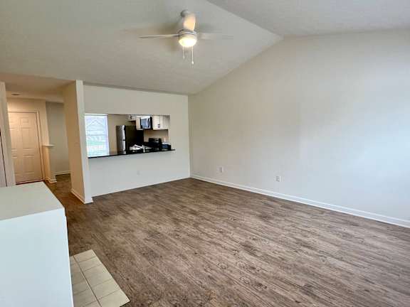 A room with a ceiling fan and a light fixture.