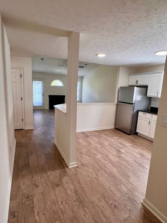 A kitchen with white cabinets and a refrigerator.