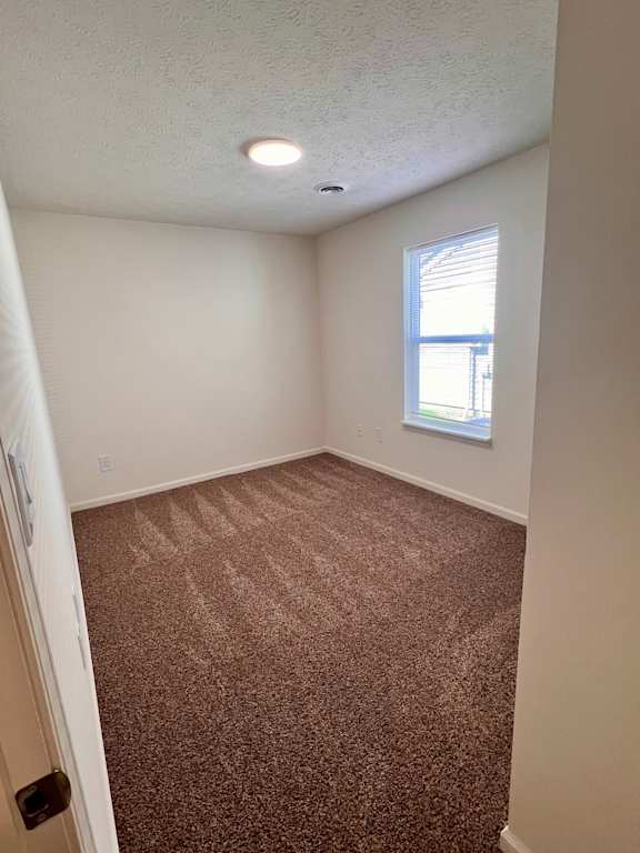 A room with a carpeted floor and a window.