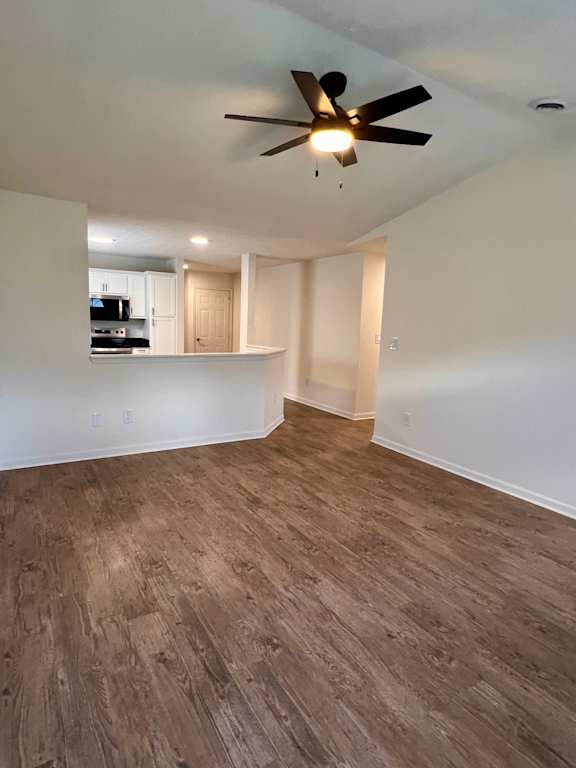 A room with a ceiling fan and wooden flooring.