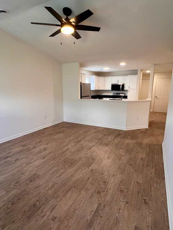 A room with a ceiling fan and wooden flooring.