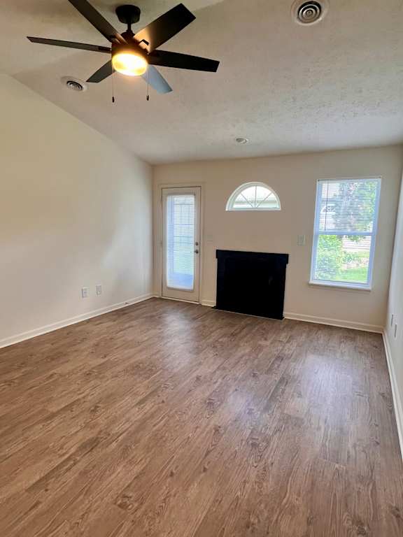 A room with a ceiling fan and wooden flooring.