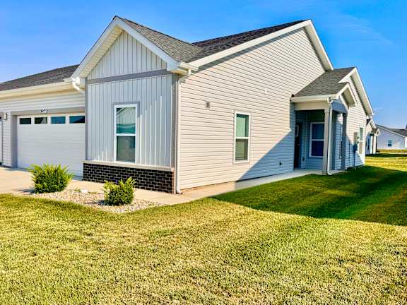 A house with a grey siding and a white garage door.