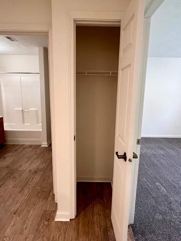 A white door with a black handle is open in a room with a wooden floor.