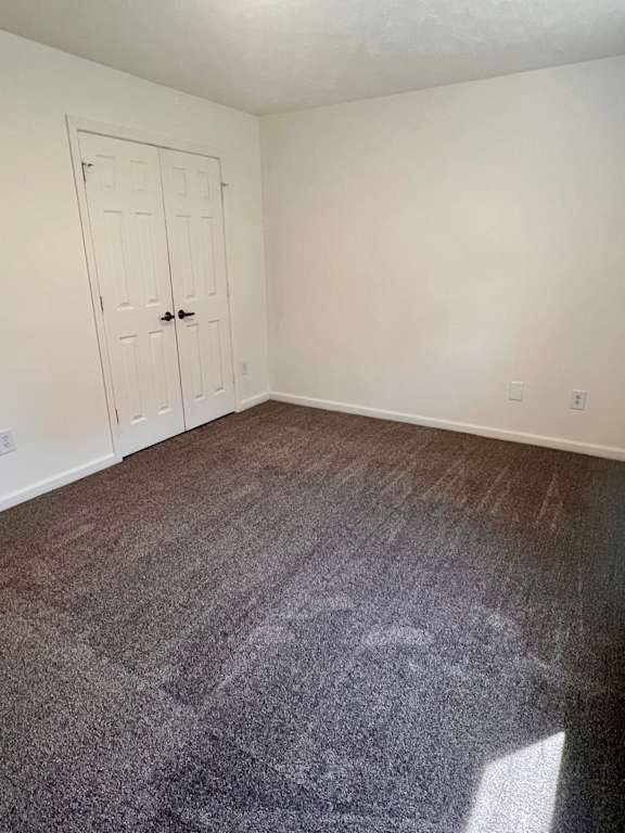 A room with a carpeted floor and a white door.