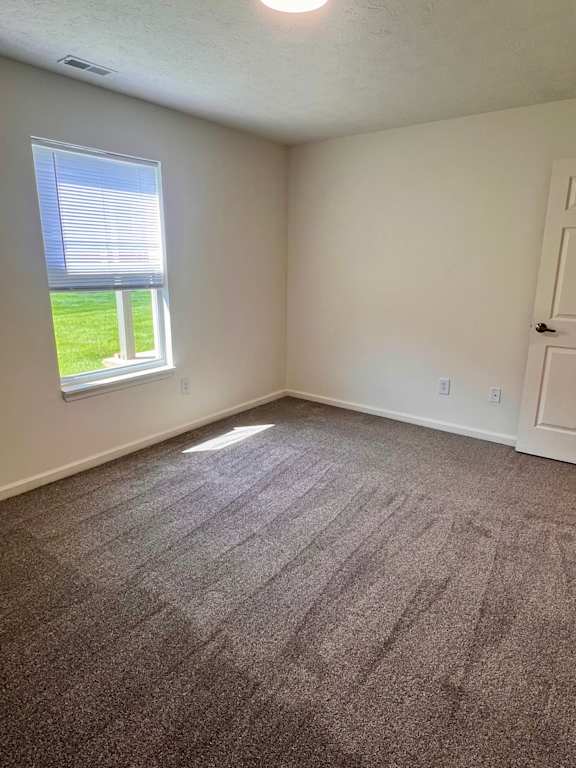 A room with a carpeted floor and a window.