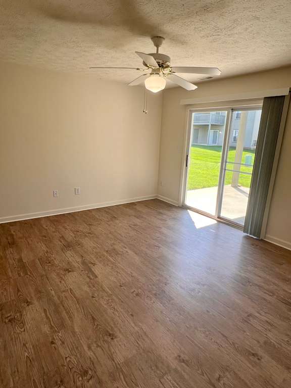 A room with a ceiling fan and sliding glass doors.