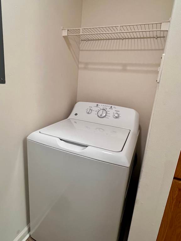 A white washing machine in a small laundry room.