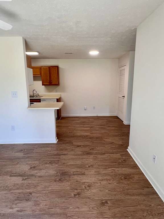 A kitchen with white walls and wooden floors.