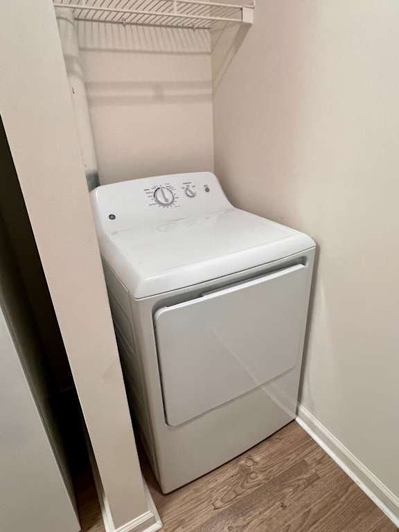 A white dryer is sitting in a small laundry room.