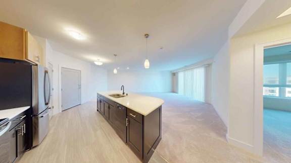A kitchen with a sink and a refrigerator.