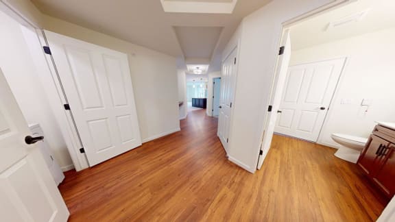a renovated living room and hallway with wood floors