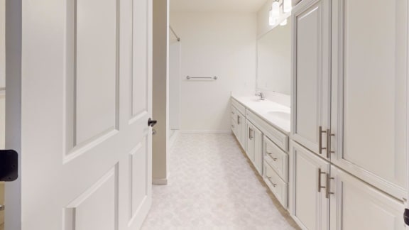 a bathroom with white cabinets and a sink and a mirror