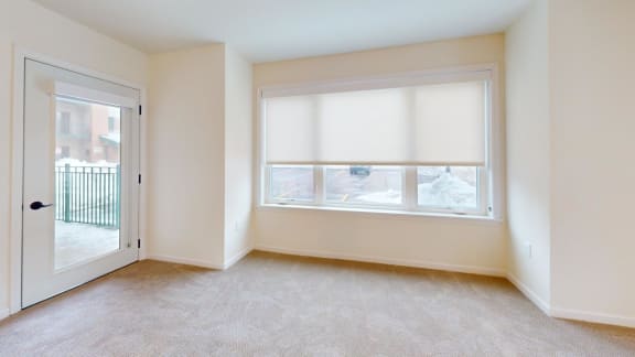 a bedroom with a large window and a door to a balcony