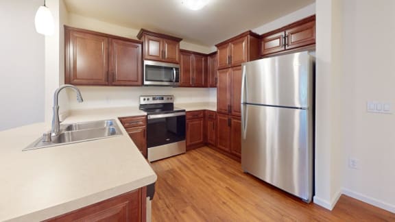 a kitchen with wooden cabinets and a stainless steel refrigerator