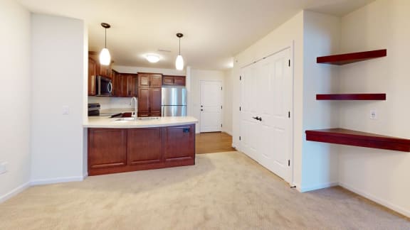 a kitchen and living room with wood cabinets and a counter