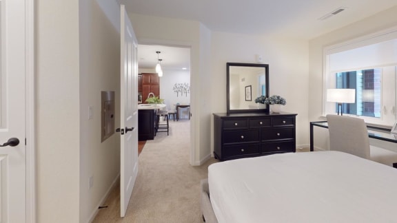 a bedroom with a white bed and a view of a living room