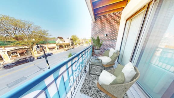a balcony with two chairs and a view of the street