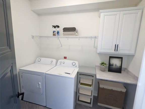 a laundry room with two washers and a dryer