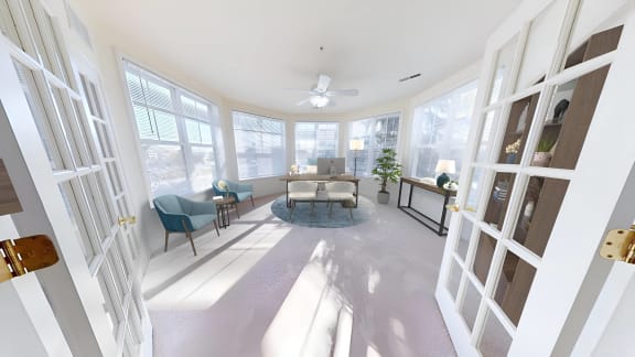 a living room with a couch and a table and windows