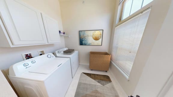 a laundry room with a washer and dryer and a window