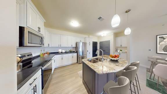 A modern kitchen with a center island and a dining area.