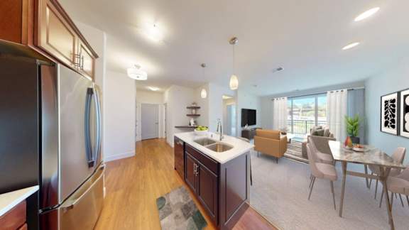 A kitchen with a refrigerator, sink, and dining table.