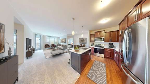 A modern kitchen with a refrigerator, microwave, and oven.