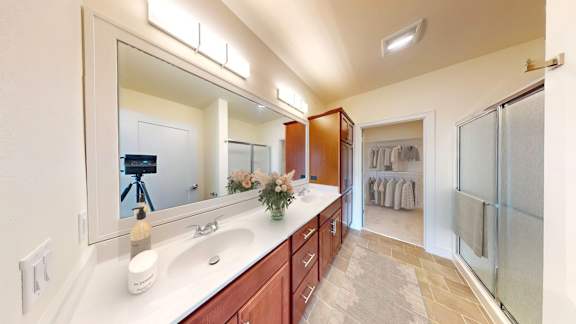 A bathroom with a vanity, mirror, and towel rack.